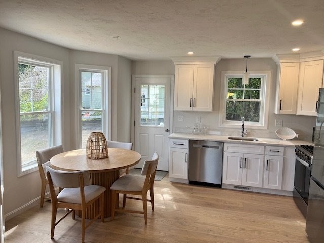 7 Ambrose Way, Unit 5 Shirley, MA 01464 - Photo 5 of 16 a kitchen with a stove a sink a dining table and chairs