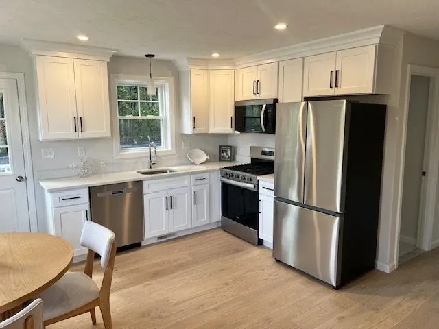 a kitchen with stainless steel appliances a refrigerator stove microwave and sink