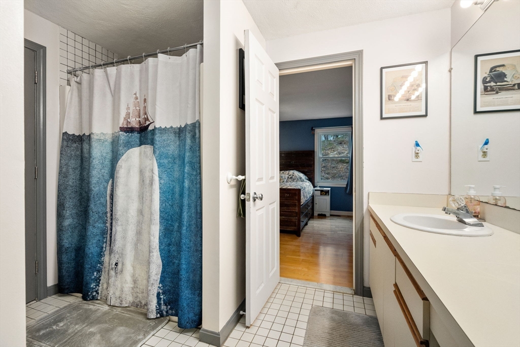 12 Oak Ridge Drive, Unit 3 Maynard, MA 01754 - Photo 20 of 34 a en suite bathroom with a sink a mirror and shower