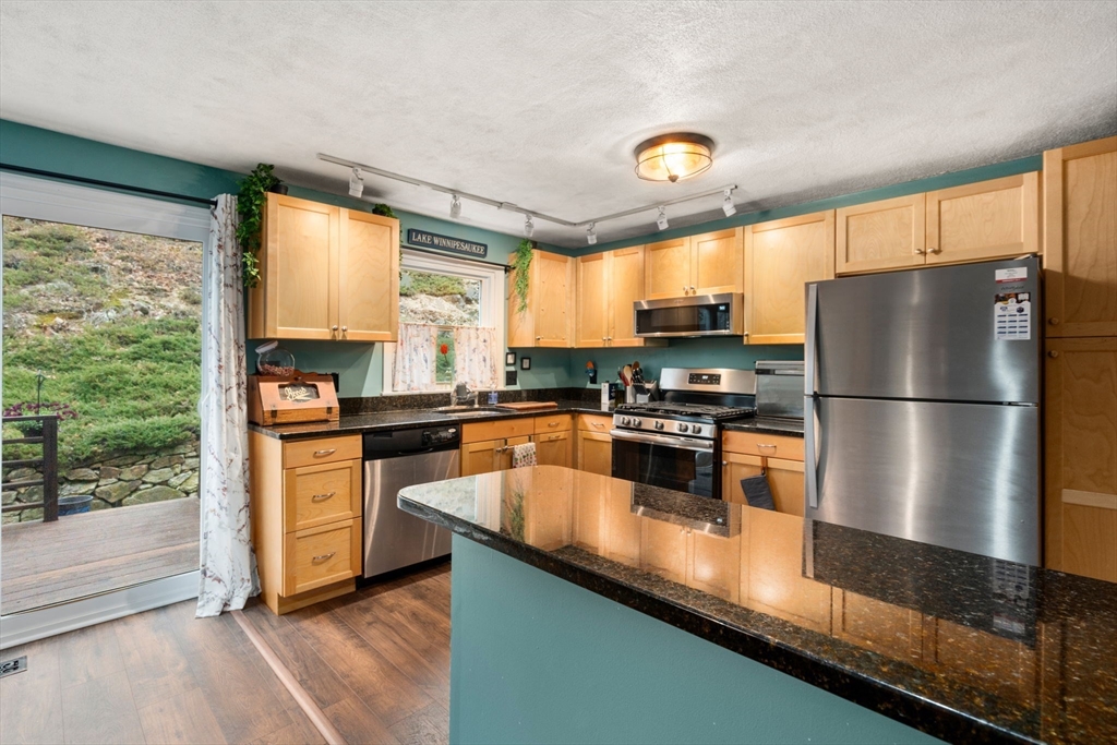 12 Oak Ridge Drive, Unit 3 Maynard, MA 01754 - Photo 10 of 34 a kitchen with granite countertop a refrigerator a stove a sink and a large window