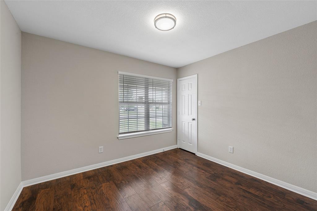 10124 Bunting Drive Waco, TX 76708 - Photo 8 of 18 an empty room with wooden floor and windows