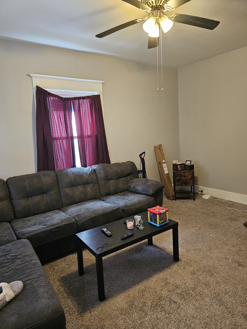 1115 14th Street Moline, IL 61265 - Photo 3 of 14 a living room with furniture a ceiling fan and a rug