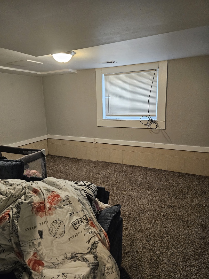1115 14th Street Moline, IL 61265 - Photo 8 of 14 a bedroom with a bed and a window