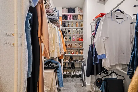 a view of walk in closet with clothes and shoes