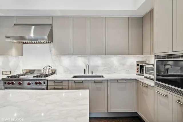 a kitchen with stainless steel appliances granite countertop a sink stove and cabinets