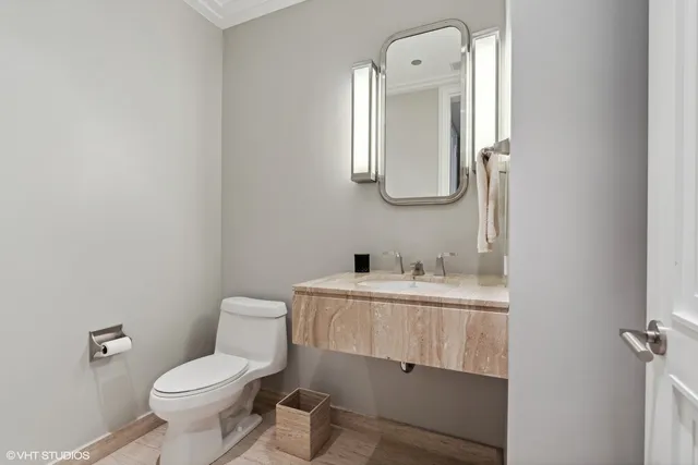 a bathroom with a toilet a sink a mirror and vanity
