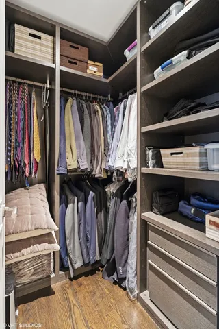 a view of walk in closet with clothes and shoes