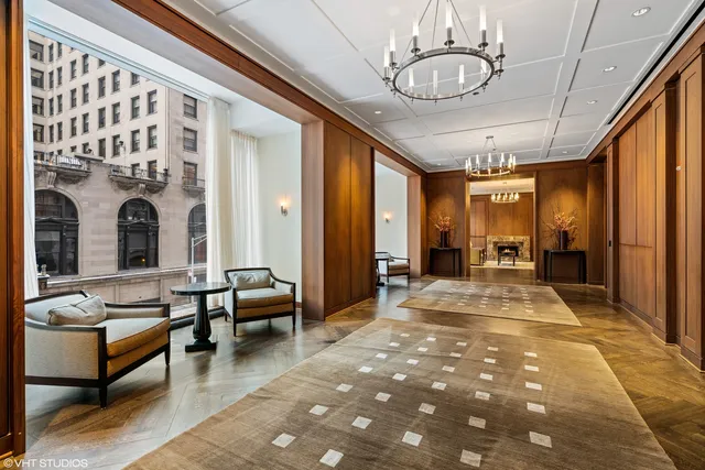 a view of a hallway with couch and chandelier