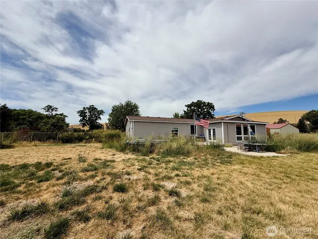 a view of a house with backyard and sitting area