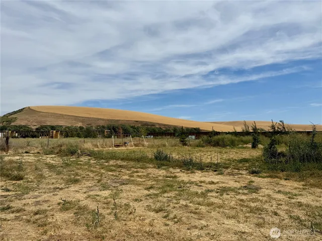 a view of a big building with a big yard and large trees