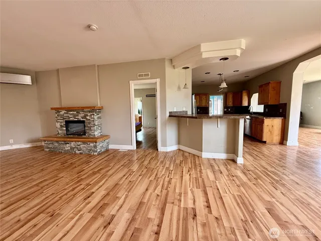 a view of a living room a kitchen with wooden floor and a sink