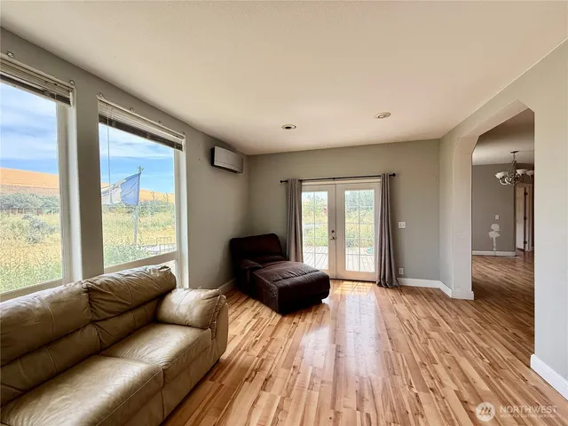 a living room with a large window and a wooden floor