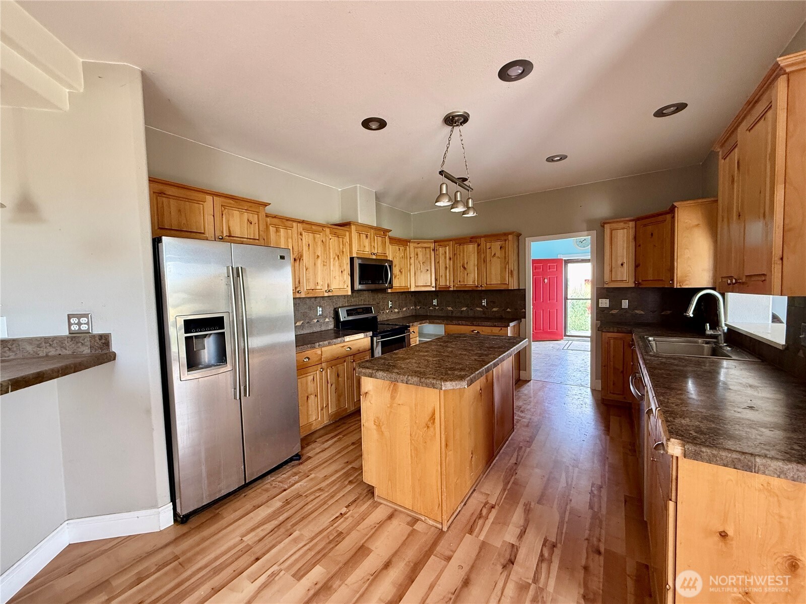 110 Main Road Dayton, WA 99328 - Photo 7 of 36 a kitchen with stainless steel appliances granite countertop a refrigerator a sink dishwasher a stove and a dining table with wooden floor