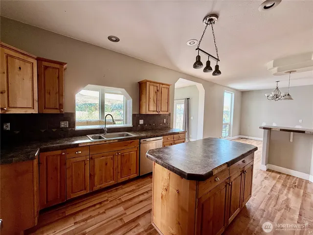 a kitchen with granite countertop a sink and a refrigerator