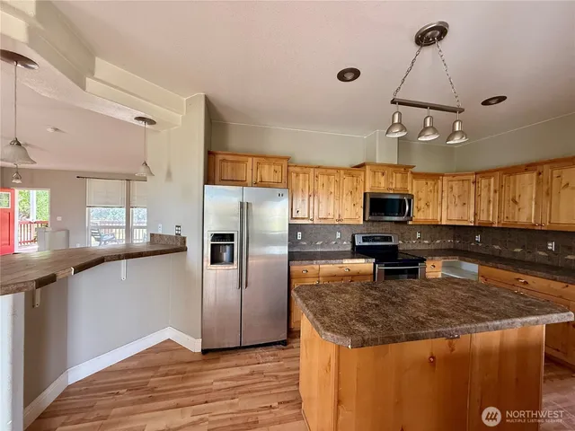 a kitchen with kitchen island granite countertop a sink appliances counter top space and cabinets