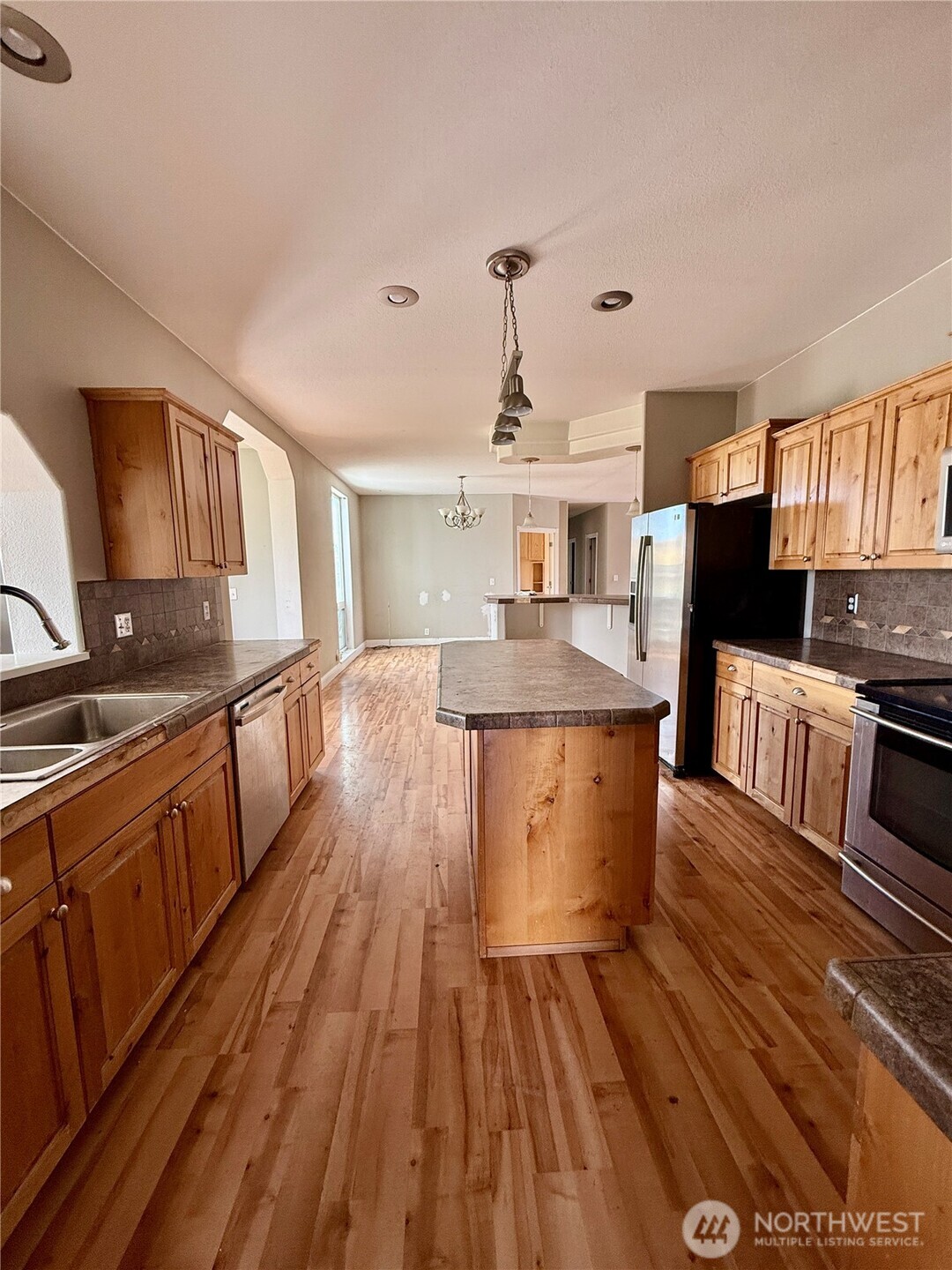110 Main Road Dayton, WA 99328 - Photo 10 of 36 a kitchen with stainless steel appliances granite countertop a stove top oven a sink dishwasher and wooden cabinets with wooden floor