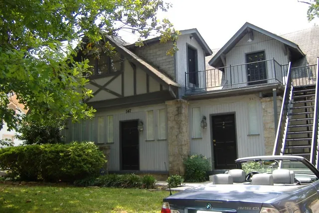 a front view of house with yard and trees around