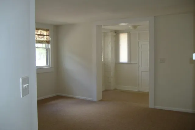an empty room with windows and closet