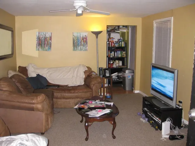 a living room with furniture a couch and a bookshelf