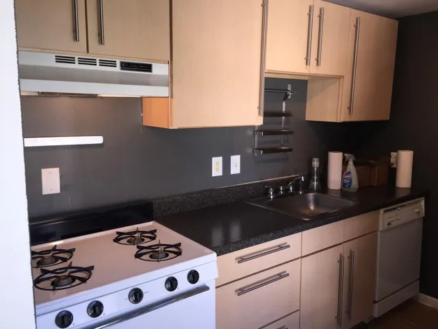 a kitchen with a sink a stove and cabinets