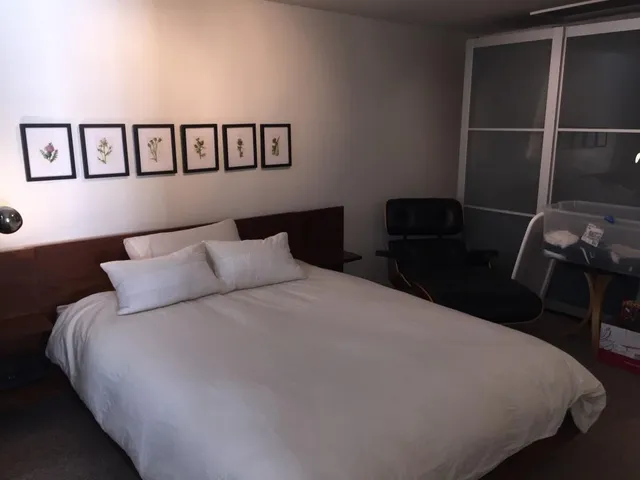 a large bed sitting in a bedroom next to a window