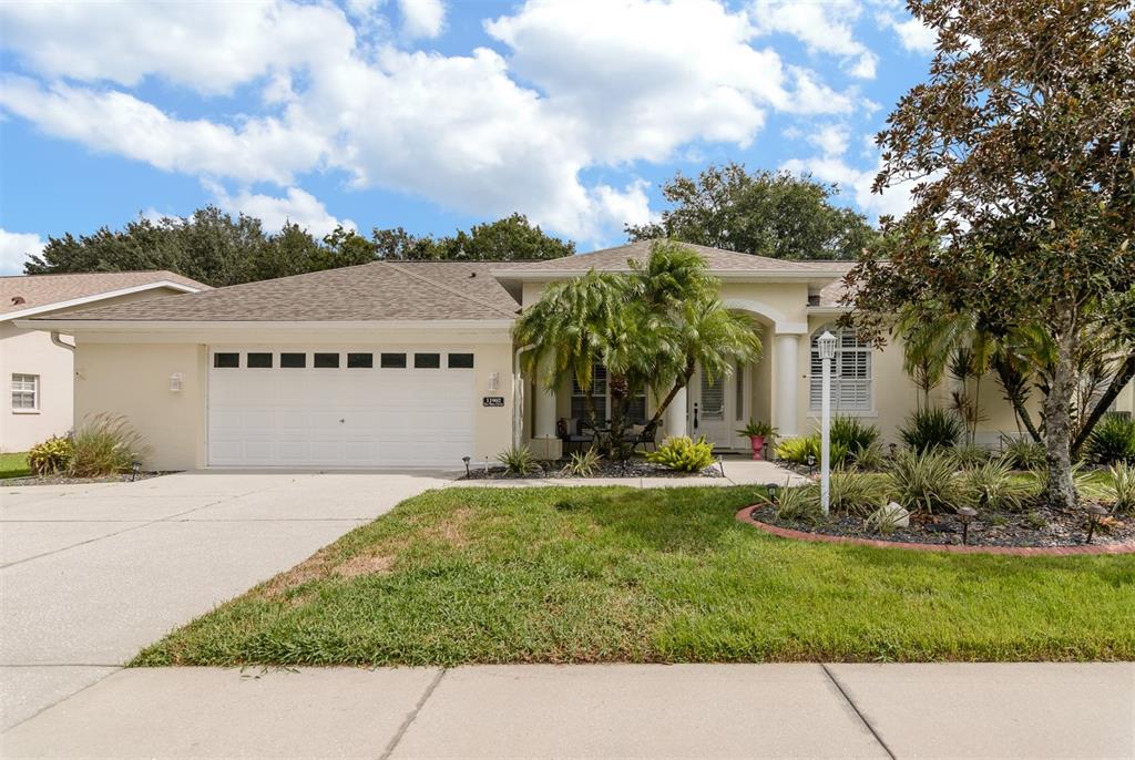 11902 Tee Time Circle New Port Richey, FL 34654 - Photo 1 of 44 a front view of a house with a yard