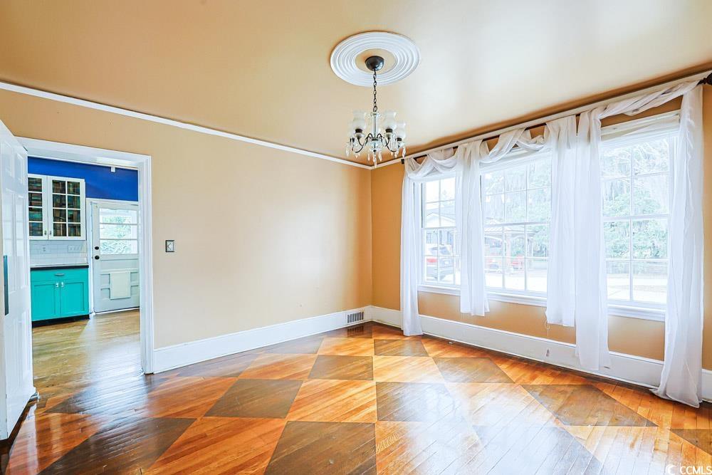 509 Beaty Street Conway, SC 29526 - Photo 12 of 40 Unfurnished dining area featuring plenty of natural light, light wood-style floors, a chandelier, and ornamental molding