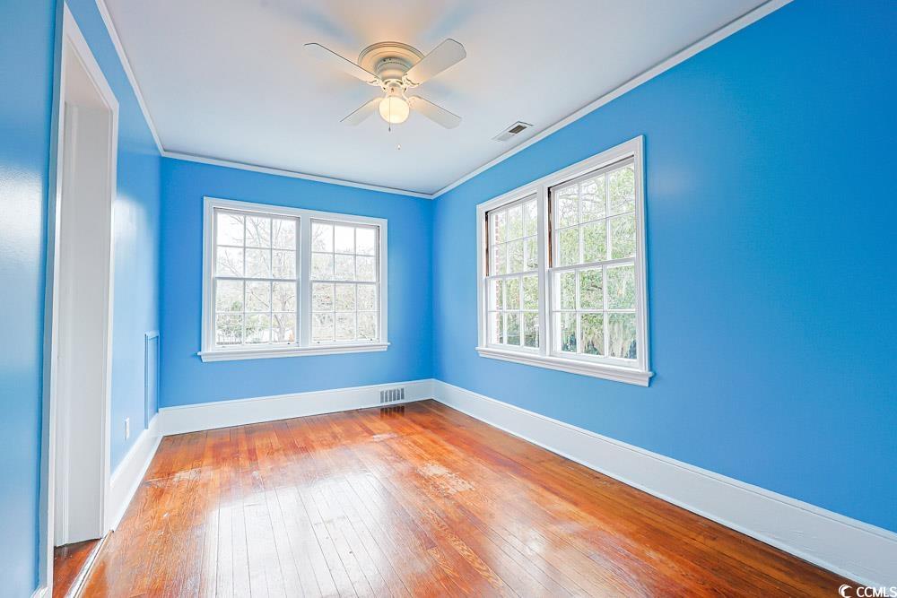 509 Beaty Street Conway, SC 29526 - Photo 15 of 40 Spare room featuring crown molding, wood-type flooring, and a ceiling fan