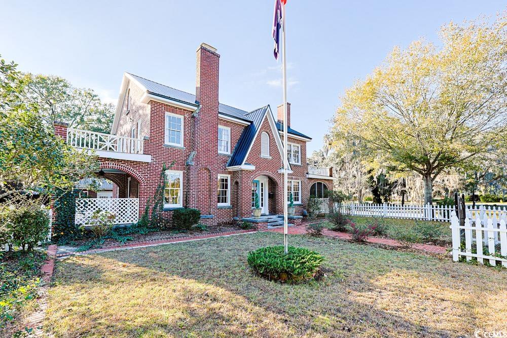 509 Beaty Street Conway, SC 29526 - Photo 40 of 40 Tudor house with a chimney, brick siding, and a metal roof