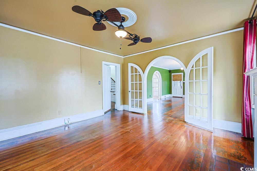 509 Beaty Street Conway, SC 29526 - Photo 5 of 40 Empty room with french doors, arched walkways, ornamental molding, hardwood / wood-style flooring, and a ceiling fan