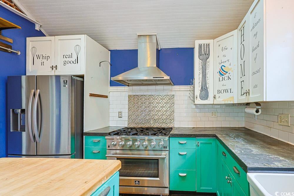 509 Beaty Street Conway, SC 29526 - Photo 9 of 40 Kitchen featuring appliances with stainless steel finishes, wall chimney exhaust hood, decorative backsplash, wooden counters, and white cabinets