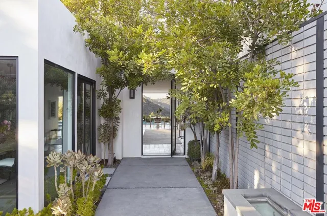 a front view of a house with a tree
