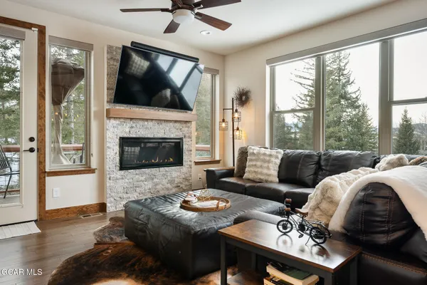 a living room with furniture a flat screen tv and a fireplace