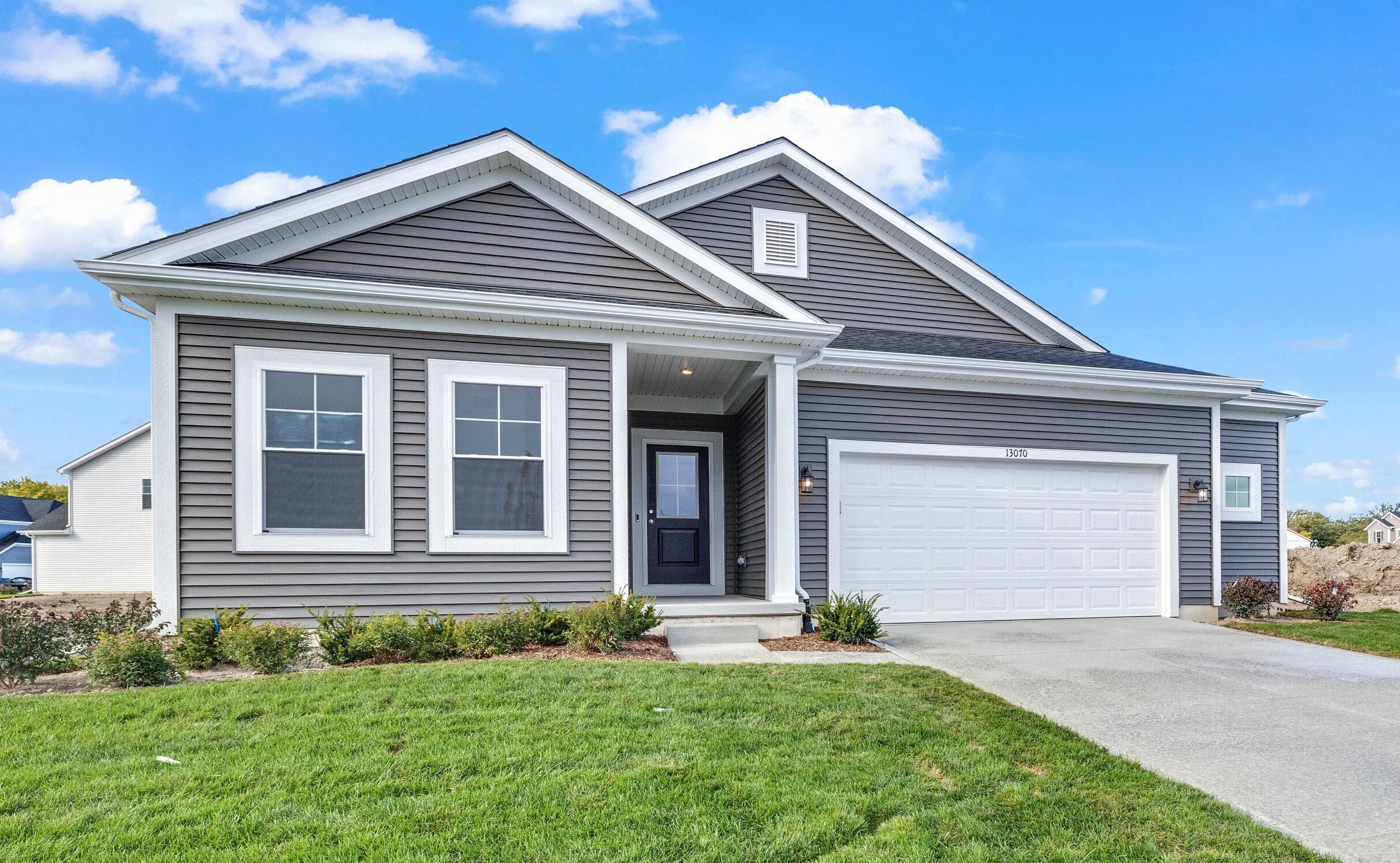 a front view of a house with a garden and garage