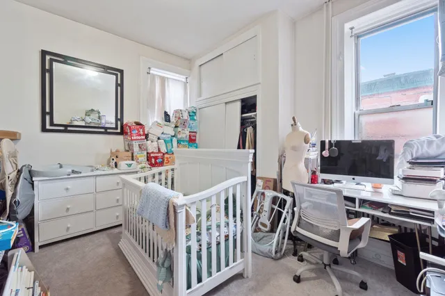 a bedroom with a bed and a computer on the table