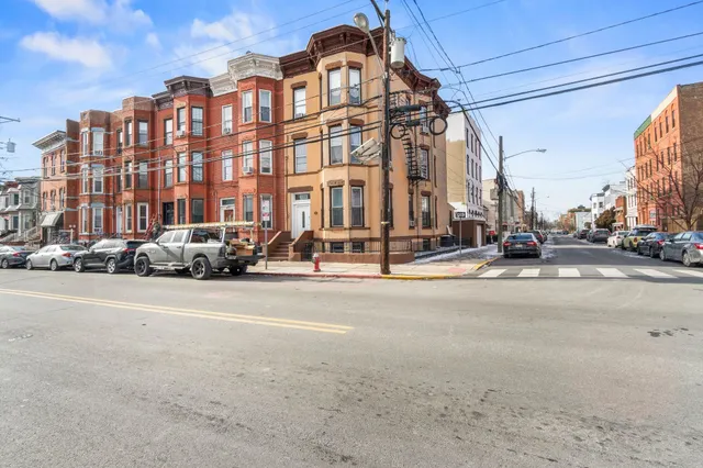a city street lined with buildings and cars parked on the roadside