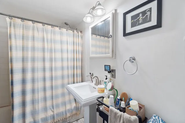 a bathroom with a sink toilet and shower curtain