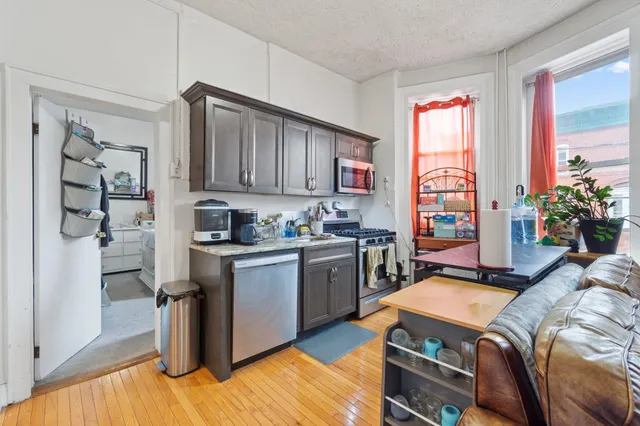 a kitchen with granite countertop a sink stove and refrigerator