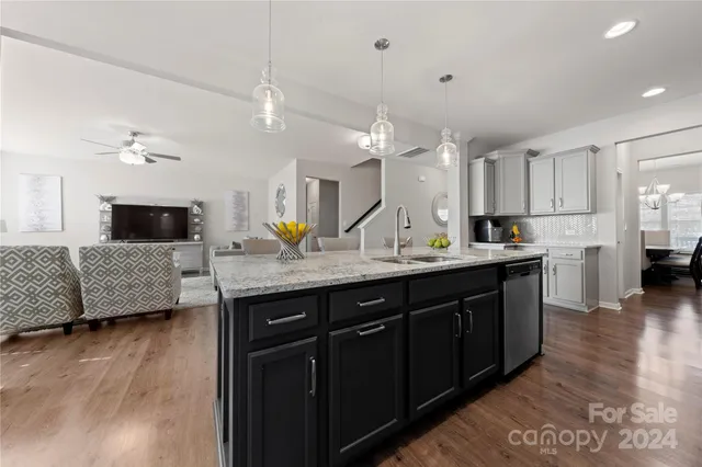 a kitchen with kitchen island granite countertop a sink and a refrigerator