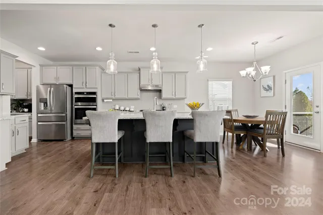 a large kitchen with kitchen island a dining table and chairs