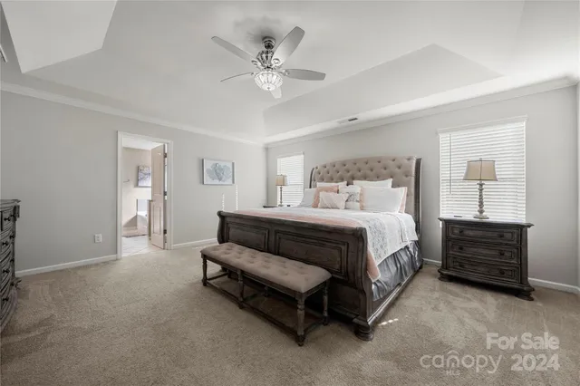 a spacious bedroom with a bed and a chandelier