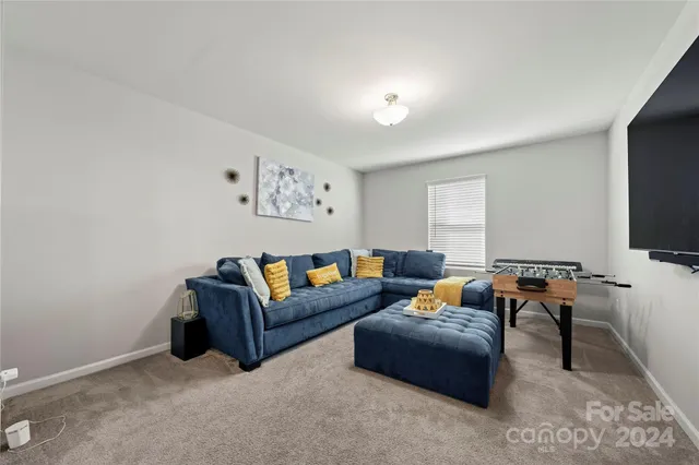 a living room with furniture a flat screen tv and a window