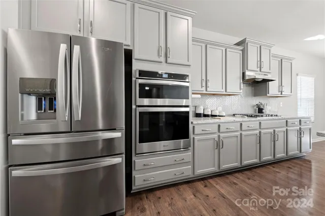 a kitchen with stainless steel appliances and white cabinets
