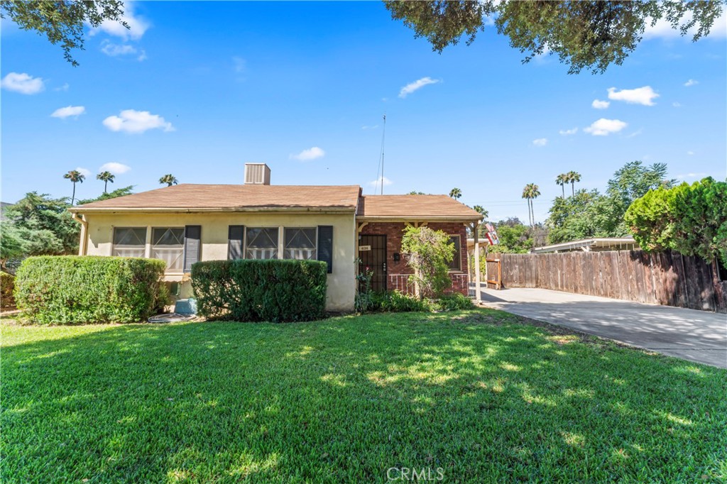 a view of a house with a yard and potted plants