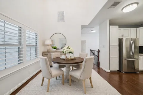a living room with furniture kitchen view and a wooden floor