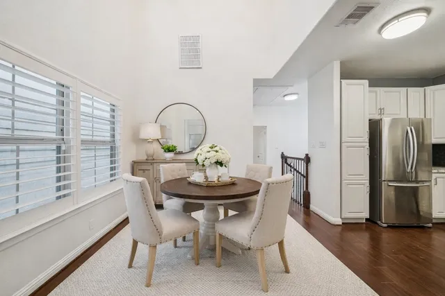 a living room with furniture kitchen view and a wooden floor