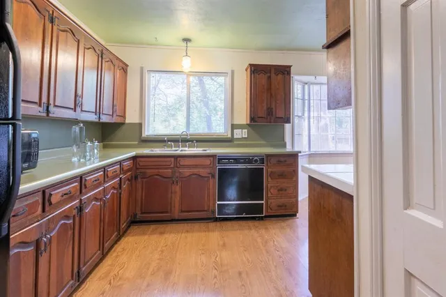 a kitchen with stainless steel appliances granite countertop wooden cabinets a stove top oven a sink and dishwasher