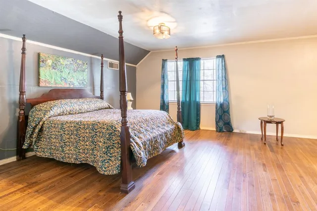 a bedroom with a large bed and a chandelier