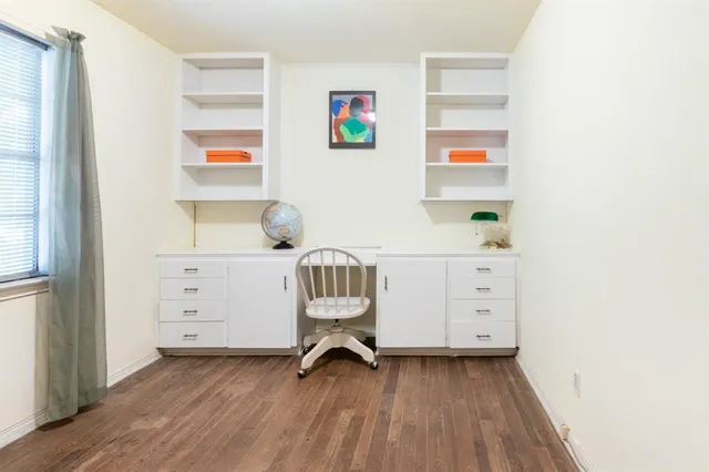 a view of a workspace with furniture and a window