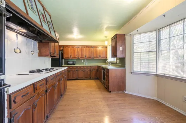 a kitchen with stainless steel appliances granite countertop a stove a sink and a refrigerator